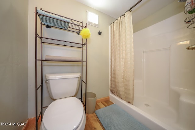 bathroom with toilet, a shower with curtain, and hardwood / wood-style floors