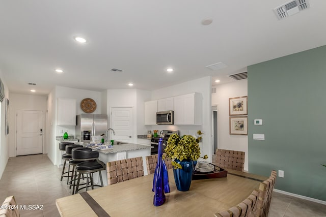 tiled dining space featuring sink