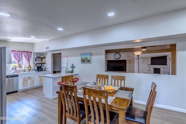 dining area with light hardwood / wood-style flooring and sink