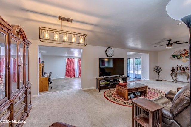 carpeted living room featuring a ceiling fan and baseboards