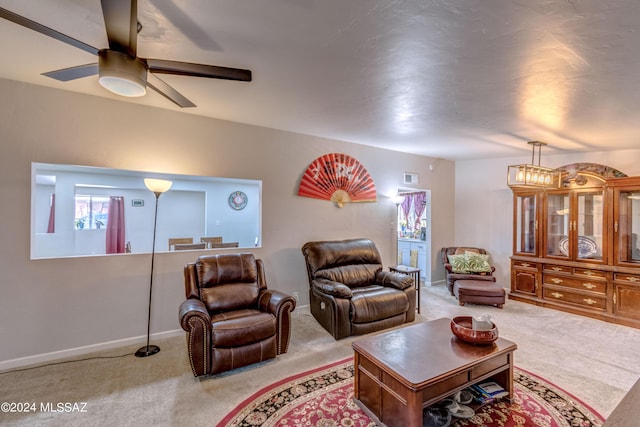 carpeted living room featuring visible vents, baseboards, and a ceiling fan