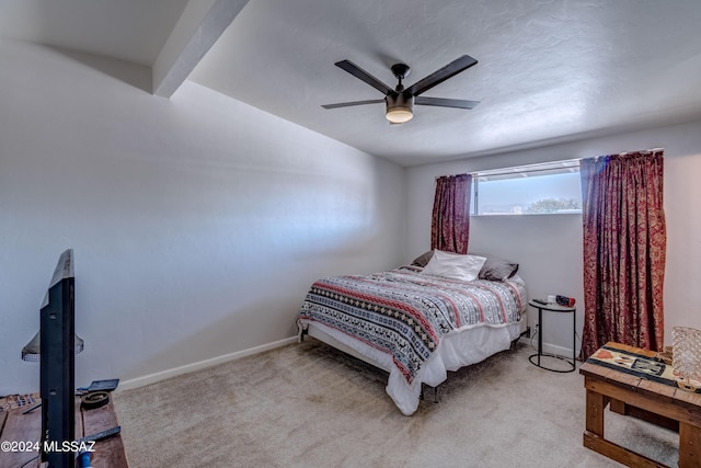 carpeted bedroom featuring ceiling fan and beam ceiling