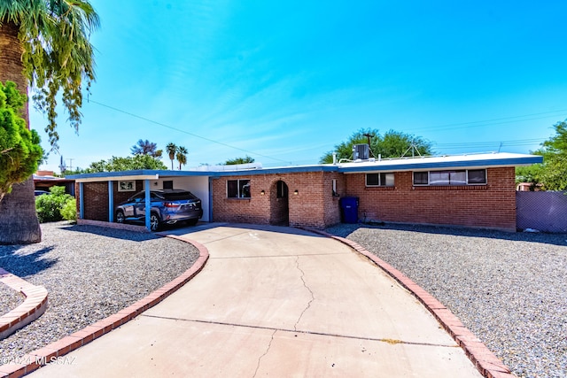 ranch-style home featuring a carport and cooling unit