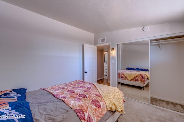 carpeted bedroom featuring vaulted ceiling, baseboards, visible vents, and a closet