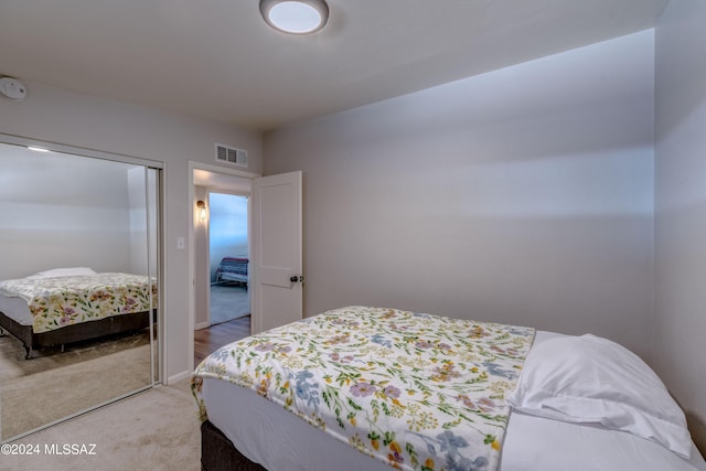 bedroom featuring visible vents, baseboards, and light colored carpet