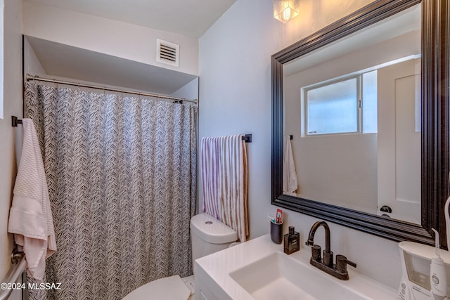 bathroom featuring visible vents, toilet, vanity, and a shower with shower curtain