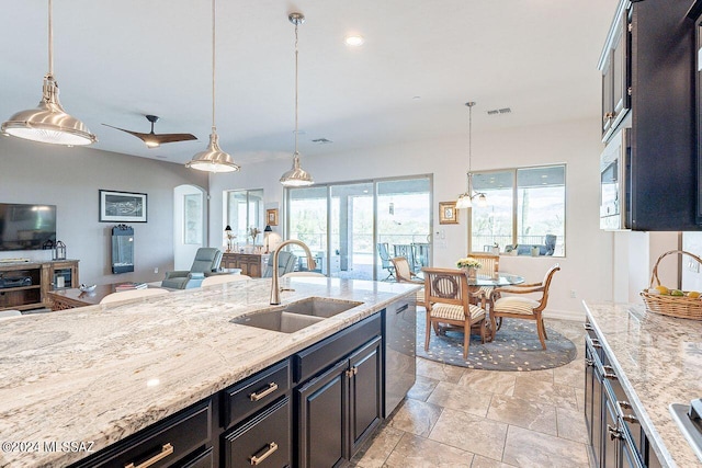 kitchen with pendant lighting, sink, and light stone countertops