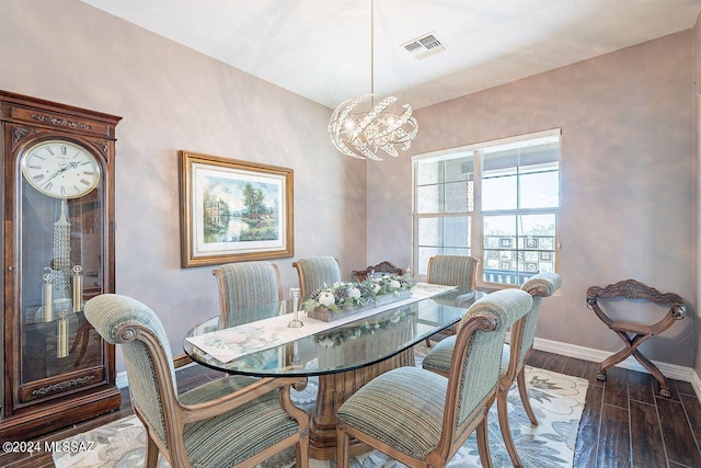 dining area featuring hardwood / wood-style floors and an inviting chandelier