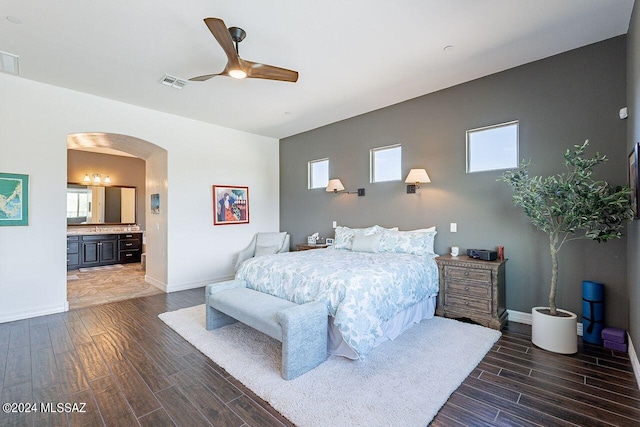 bedroom with ceiling fan, ensuite bath, and dark hardwood / wood-style flooring