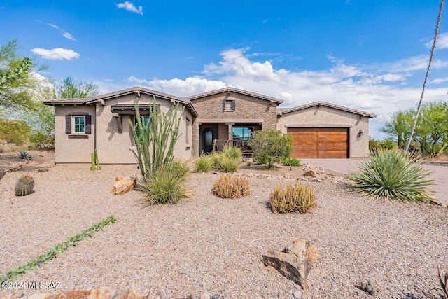 view of front of property featuring decorative driveway, an attached garage, and stucco siding