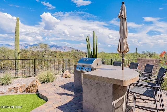 view of patio / terrace with an outdoor kitchen, a mountain view, and an outdoor bar