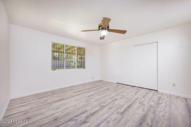 empty room with ceiling fan and light hardwood / wood-style flooring