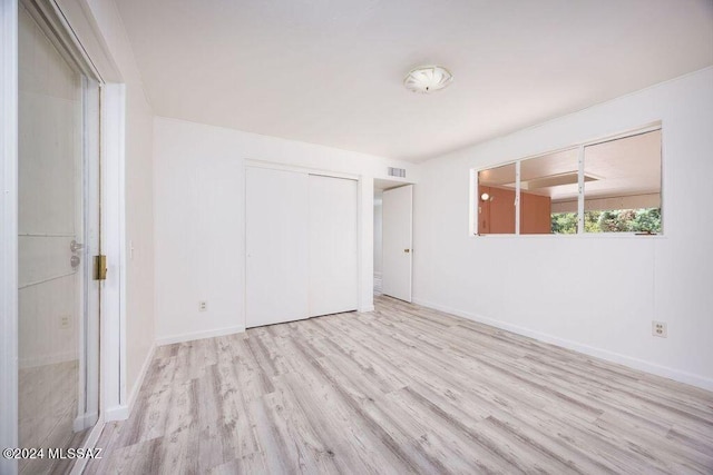 unfurnished bedroom featuring a closet and light hardwood / wood-style floors