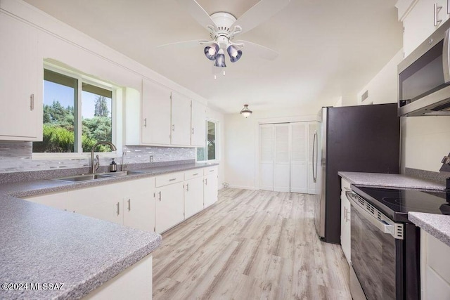 kitchen with ceiling fan, light wood-type flooring, tasteful backsplash, range, and sink