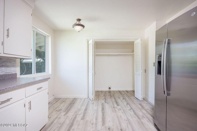 kitchen featuring stainless steel fridge with ice dispenser, backsplash, light hardwood / wood-style flooring, and white cabinetry