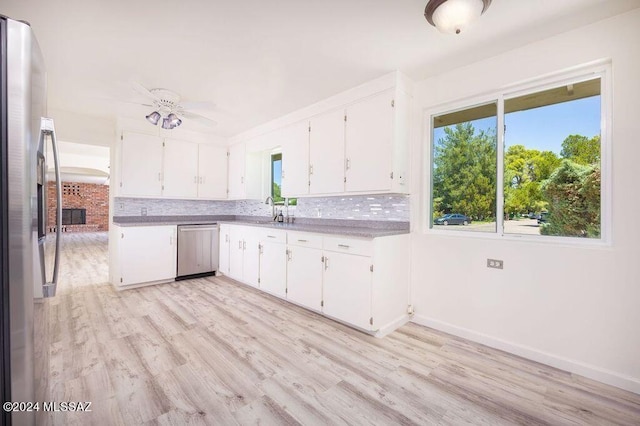 kitchen featuring dishwashing machine, ceiling fan, light hardwood / wood-style floors, and a healthy amount of sunlight