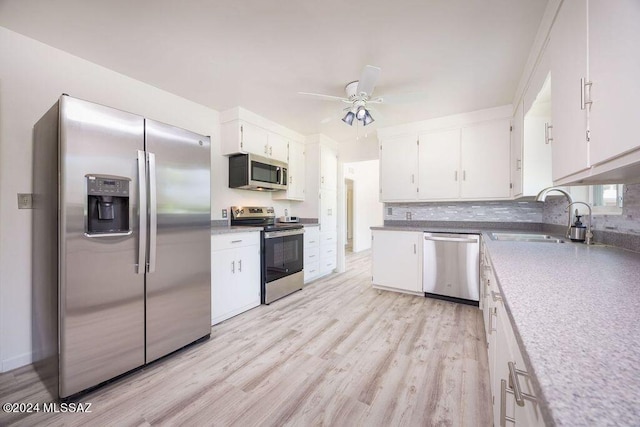 kitchen with light hardwood / wood-style floors, stainless steel appliances, ceiling fan, and white cabinetry