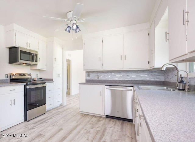 kitchen featuring stainless steel appliances, white cabinetry, and light wood-type flooring