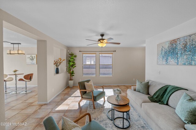 tiled living room featuring ceiling fan and plenty of natural light