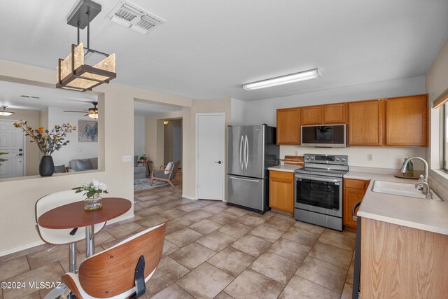 kitchen featuring ceiling fan, light tile patterned floors, stainless steel appliances, and sink