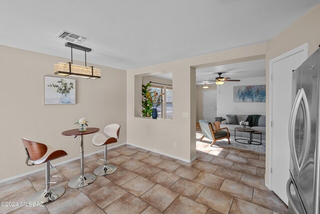 tiled dining area with ceiling fan