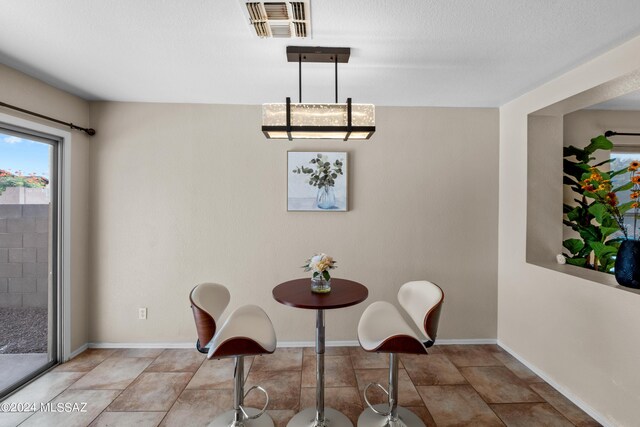 dining area featuring an inviting chandelier and light tile patterned floors