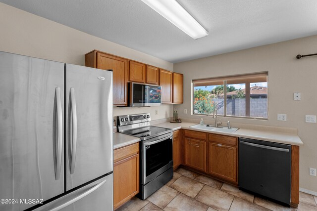 kitchen featuring light tile patterned floors, stainless steel appliances, and sink