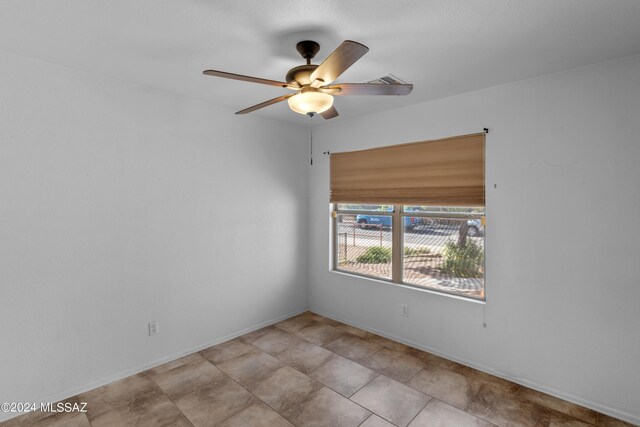 empty room with ceiling fan and light tile patterned flooring