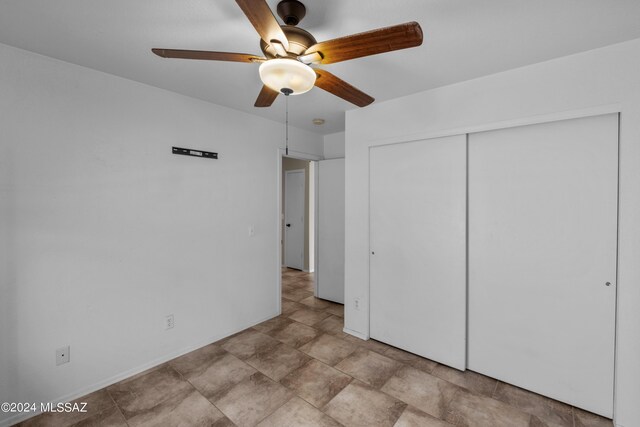 unfurnished bedroom with a closet, ceiling fan, and light tile patterned floors