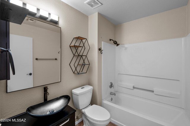 full bathroom featuring vanity, toilet, a textured ceiling, and shower / bath combination