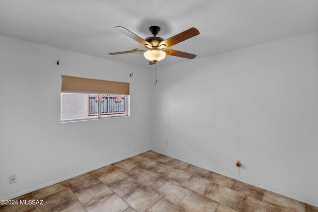 empty room with light tile patterned floors and ceiling fan