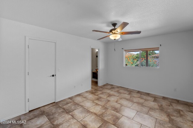 unfurnished room featuring ceiling fan, a textured ceiling, and light tile patterned flooring