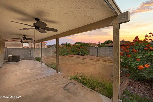 patio terrace at dusk featuring cooling unit and ceiling fan