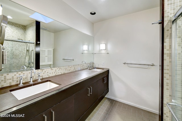 bathroom with vanity, a shower with shower door, and backsplash