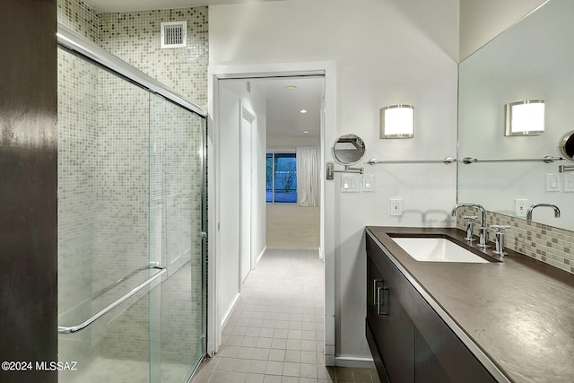 bathroom featuring a shower with shower door and vanity