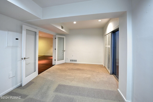 carpeted empty room with electric panel and french doors