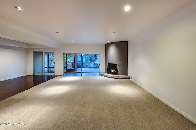 unfurnished living room featuring wood-type flooring and a large fireplace