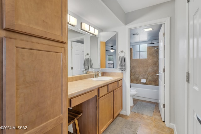 full bathroom with toilet, tile patterned floors, tiled shower / bath, vanity, and ceiling fan