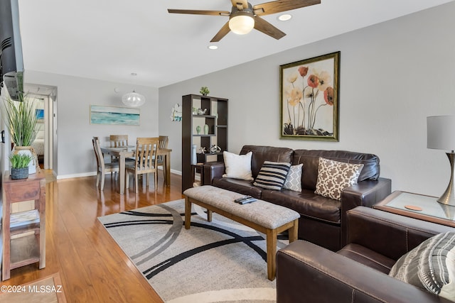 living room featuring hardwood / wood-style floors and ceiling fan