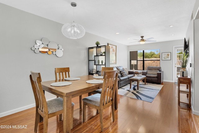 dining room featuring hardwood / wood-style floors and ceiling fan with notable chandelier