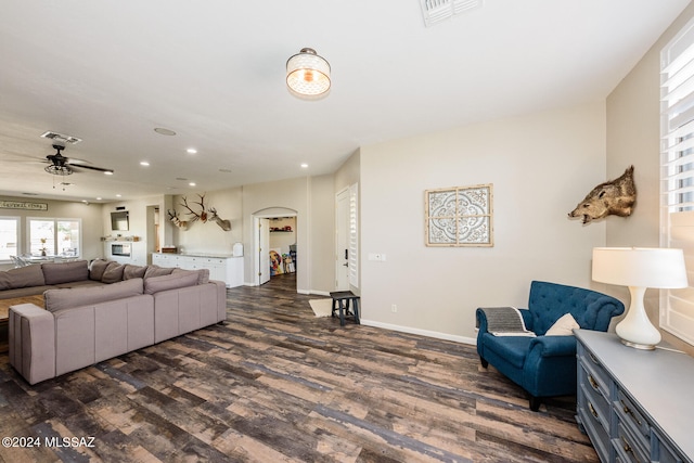 living room featuring dark wood-type flooring and ceiling fan