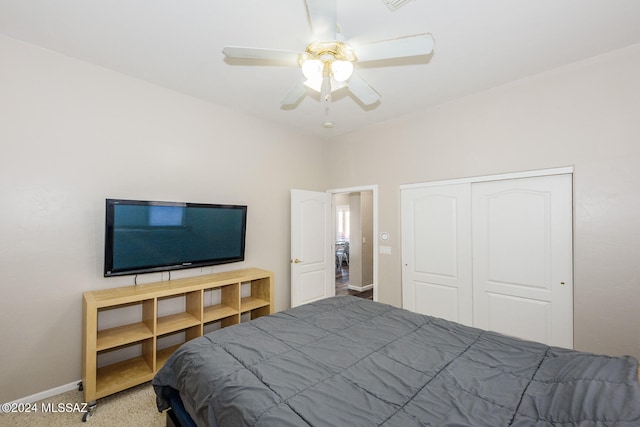 carpeted bedroom with ceiling fan and a closet