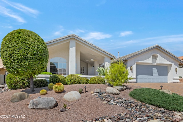 view of front of home featuring ceiling fan and a garage