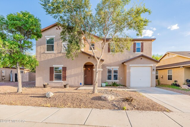 view of front of house with a garage, concrete driveway, and stucco siding