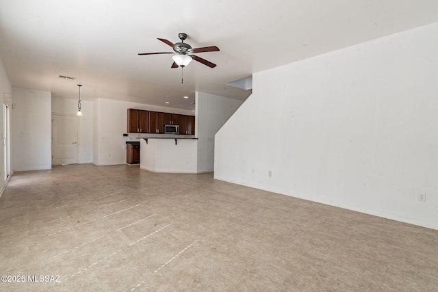 unfurnished living room with visible vents and ceiling fan