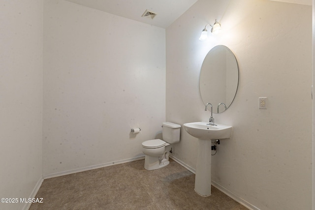 half bathroom with toilet, baseboards, and visible vents