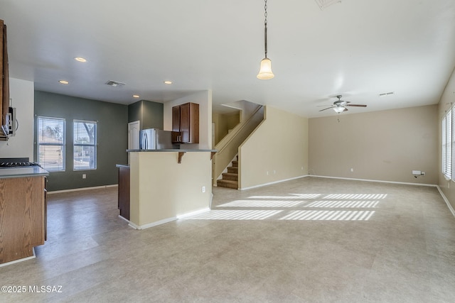 kitchen with stainless steel fridge, pendant lighting, and ceiling fan