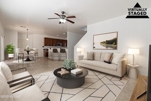 living room featuring a ceiling fan, visible vents, and concrete floors