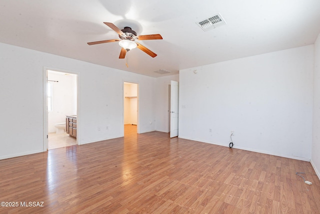 spare room featuring light wood-style flooring, visible vents, ceiling fan, and baseboards