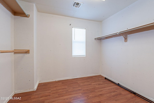 walk in closet with visible vents and wood finished floors